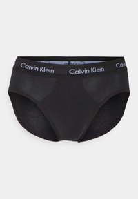 Schwarze Baumwollslips mit einem weichen, elastischen Bund und weißem "Calvin Klein"-Logo. Glatte Textur und klassisches Design mit einem tiefen Schnitt.