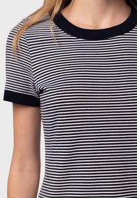 T-shirt en tricot rayé bleu marine et blanc, avec un col rond côtelé et des manches courtes dotées de poignets bleu marine unis. Texture douce et coupe ajustée.