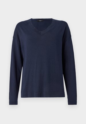 Tumši zila krekla formas adīta V-veida kakla džemperis ar garām piedurknēm. Mīksts, viegls audums ar brīvu piegriezumu un ribinātiem piedurkņu galiem. Vienkāršs, minimālisma dizains bez rakstiem.