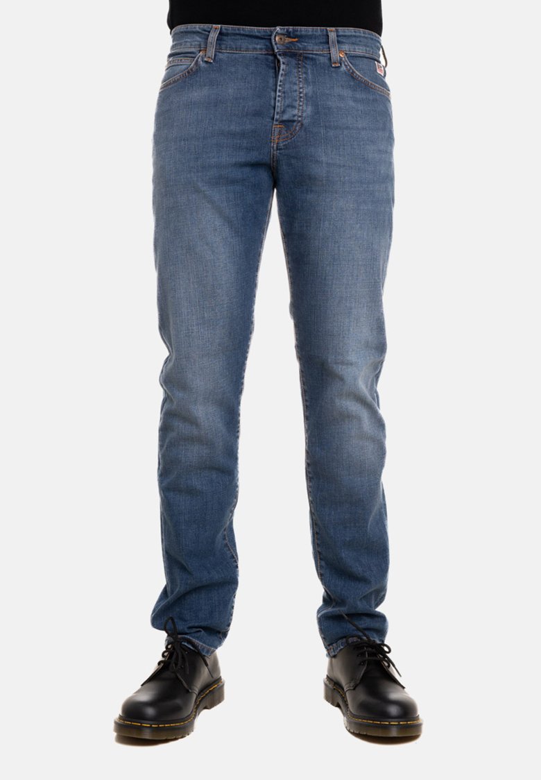 Jeans in denim blu con una vestibilità slim, cinque tasche, cuciture arancioni a contrasto e un’etichetta con il marchio sul retro. Abbinati a stivali neri con lacci.