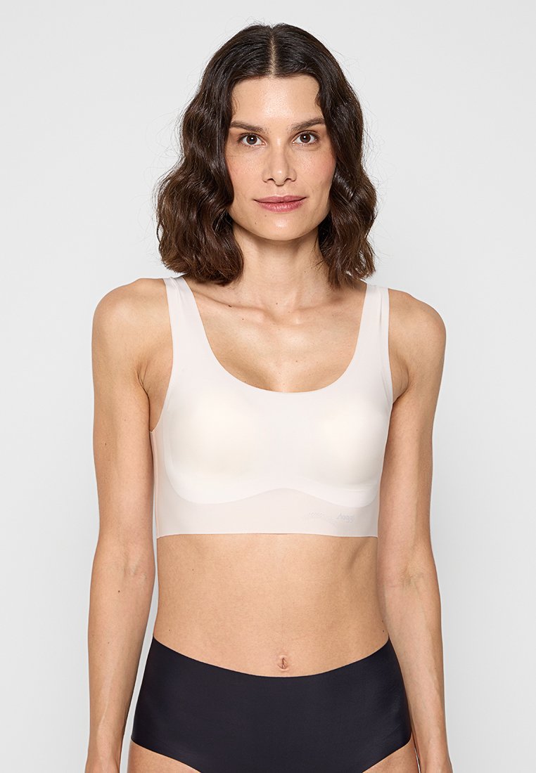 Lätt, sömlös bh i mjukt beige material med breda band och en slät yta. Designad för komfort utan synliga linjer.