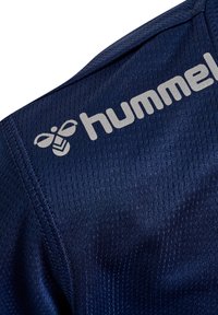 Maillot de sport marine en tissu texturé avec un motif à rayures subtil. Muni d'un logo "hummel" gris clair et d'un emblème d'abeille.