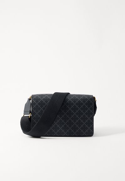Zwarte crossbody tas met geometrisch patroon, gladde textuur, gouden hardware accenten en een geweven schouderriem. Compact rechthoekige vorm.