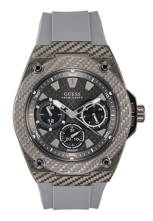 Zegarek na rękę GUESS z szarym silikonowym paskiem, teksturowaną srebrną lunetą, czarną tarczą, trzema subtarczami oraz srebrnymi indeksami godzin i wskazówkami.