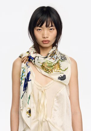 Jedwabny szal z kremowym tłem ozdobiony kolorowymi nadrukami owadów i motywów przyrodniczych w odcieniach zieleni, niebieskiego i brązu. Lekka i miękka faktura.