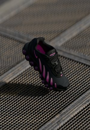Juodos sportinės bateliai su rožinėmis detalėmis, turintys tekstūruotą viršutinę dalį, išsiskiriantį pado dizainą su oro burbulų detalėmis ir raištelių sistemą.