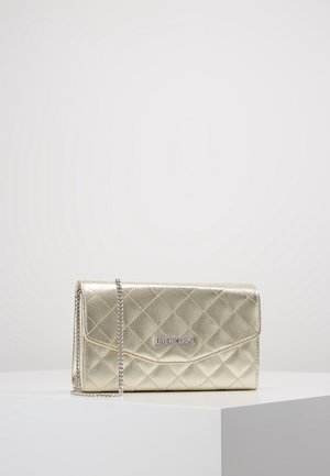 Gouden doorgestikte leren clutch met zilveren kettingriem en "LOVE MOSCHINO" logo aan de voorkant, tentoongesteld op een wit voetstuk.