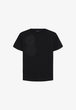 Maglietta nera a maniche corte con due grandi e intricate fantasie circolari in pizzo sul lato superiore sinistro della parte anteriore.