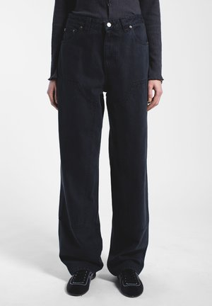 Donkerblauwe wijde broek gemaakt van katoenen denim, met grote zijzakken, zichtbare stiksels en een hoge taille.