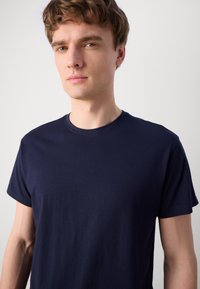 Navy blå bomulls t-skjorte med klassisk rund hals og korte ermer, med en jevn tekstur og minimalistisk design.