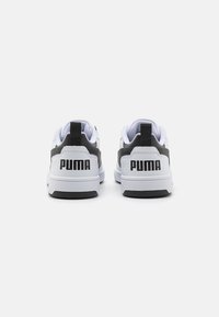 Weiße und graue Sneakers mit schwarzen Akzenten. Aus Nubuk- und Mesh-Materialien. Mit einem auffälligen "PUMA"-Logo an der Ferse und einer Schlaufe. Gummisohle.