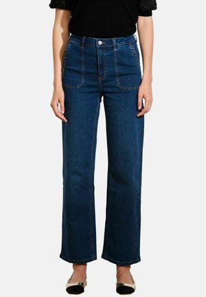 Kõrge vöökoht, laiad jalgadega sinised denim teksad, millel on kaks esimest taskut, kontrastsete õmblustega ja eesnupu kinnitusega. Sile tekstuur.