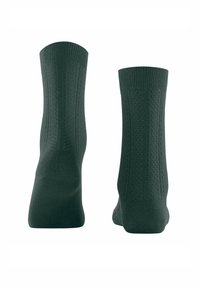 Chaussettes en coton vert foncé avec des bords côtelés, présentant un motif texturé sur les côtés et un semelle intérieure lisse pour plus de confort.