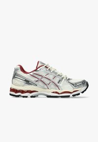 Scarpa da corsa bianca e argento con accenti rossi, tomaia in rete, suola ammortizzata e design con lacci mostrata di lato su uno sfondo bianco.