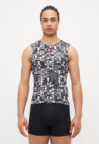 Ärmelloses Oberteil in schwarz-weißer geometrischer Musterung, mit rundem Ausschnitt und taillierter Passform, kombiniert mit schwarzen Boxershorts.