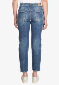 Jeans in denim blu con taglio dritto, orli sfilacciati e due tasche posteriori con un design di cucitura decorativa.