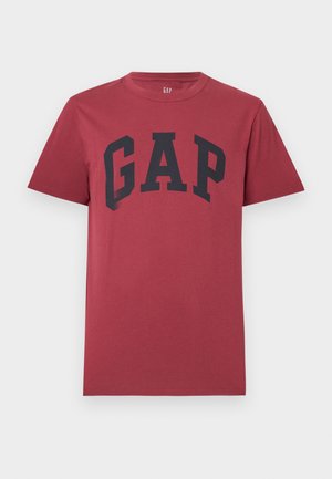 Camiseta roja de manga corta con cuello redondo y gran texto negro "GAP" centrado en el pecho.