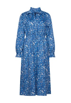 Robe midi bleue avec manches longues, taille élastique, col haut avec nœud papillon, présentant un motif floral blanc et marine.