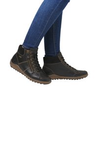 Schwarze Leder-Hochschuhe mit strukturiertem Finish, seitlichem Reißverschluss und Gummisohle mit Traktionsmustern. Abgesetzt mit braunen Nähten und Ösen.