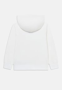 Sudadera blanca de algodón con un bolsillo canguro, puños y dobladillo acanalados. Presenta una textura suave y un diseño de capucha redondeada.