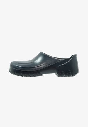Sabot noir à enfiler avec une semelle épaisse et texturée et un dessus lisse et arrondi, présenté de profil sur fond blanc.