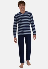Langärmliges, marineblau gestreiftes Oberteil mit hellblauen und weißen Streifen, kombiniert mit dunkelblauen Hosen. Weicher Stoff mit entspannter Passform.