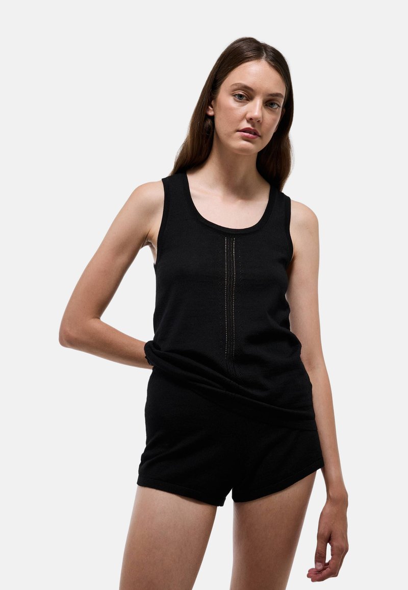 Débardeur sans manches noir avec un col rond et des détails texturés verticaux à l'avant, assorti avec un short noir.