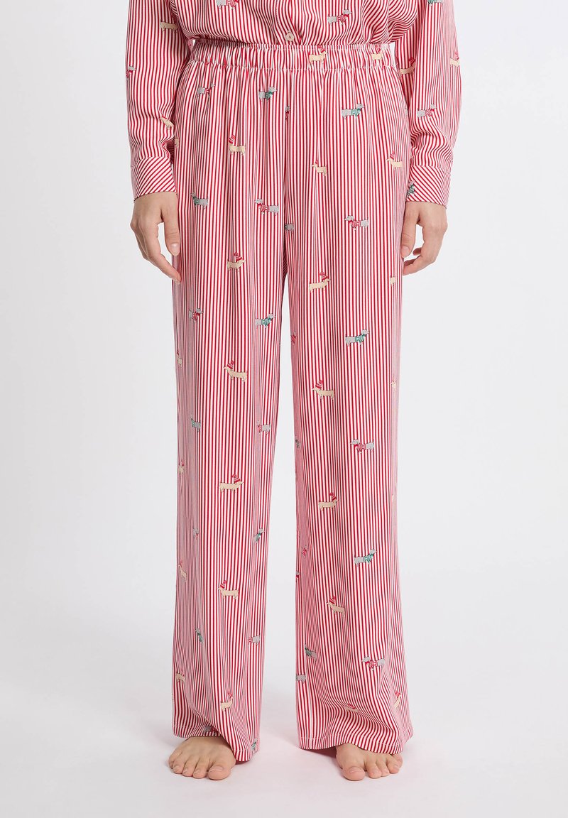 Rode en witte gestreepte pyjamabroek met een relaxte pasvorm, elastische tailleband en kleine, multicolore hondpatronen overal. Zachte stoftextuur.