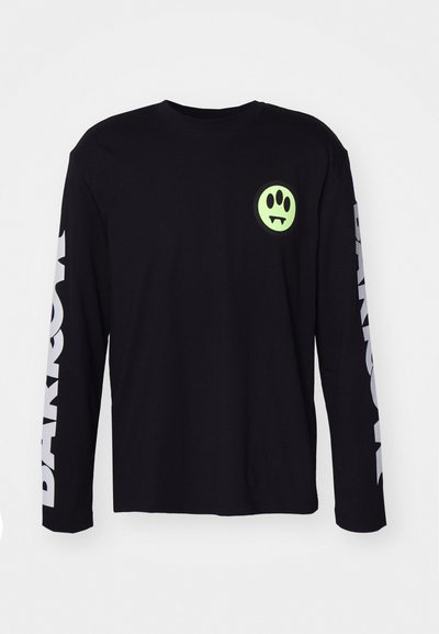 Sort langærmet t-shirt lavet af bomuld, med et grønt spøgelse grafisk tryk på brystet og hvid tekst på ærmerne.