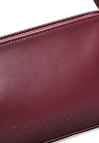 Calvin Klein EMBOSSED LOGO SHOULDER BAG - Kézitáska - oxblood