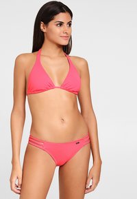 Roze bikini set met een triangeltop en bijpassende broek met drie horizontale banden aan de zijkanten voor extra detail. Gladde stoftextuur.