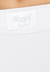 Tessuto bianco elastico con una texture liscia e un'etichetta ricamata con il nome del marchio "sloggi". Design minimalista.