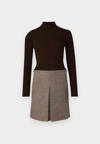 Brun ribbestrikket turtleneck topp kombinert med et rutete skjørt med plisse-detalj, begge laget av myk, teksturert stoff.