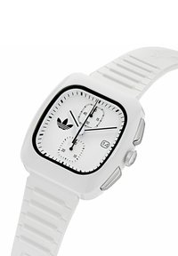 Ceas digital pătrat alb cu brățară din silicon texturată, accente negre, sub-cadrane pentru cronograf și un display pentru dată.