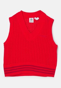 Rode gebreide mouwloze trui met V-hals, voorzien van een textured mesh patroon en een gestreepte ribbelzoom. Adidas-logo zichtbaar.
