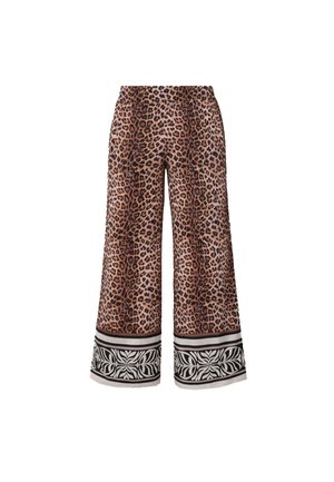 Pantaloni a gamba larga con stampa leopardata marrone e nera e polsini con motivo floreale bianco e nero su sfondo bianco.