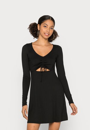 Vestido preto de mangas longas com decote em V, frente franzida e detalhe de cintura recortada. Feito de um tecido suave e elástico com um corte descontraído.