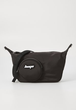 Zwarte crossbodytas met een ronde voorzak met een wit "hugo" logo en een verstelbare schouderband met een reliëfmerk.