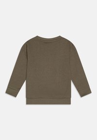 Alyvuogių žalia medvilnės megztinis su ilgomis rankovėmis, gipiūrinėmis apykaklėmis ir apačia, bei apvalia iškarpa; minkšta tekstūra ir minimalistiškas dizainas.