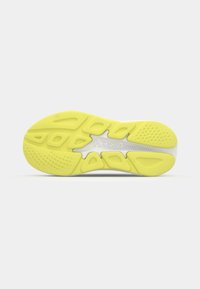 Hoka footwear sole featuring vibrant yellow rubber with a textured design, multiple cutouts, and a contrasting white section in the center.