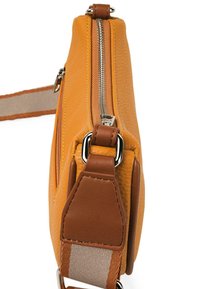 Bolso de cuero texturizado amarillo con un zipper plateado y acentos marrones. Cuenta con una correa desmontable con rayas naranjas y beige.