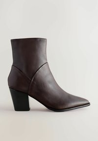 Stivale corto in pelle marrone scuro con punta appuntita e tacco a blocco, design senza cuciture su uno sfondo chiaro.