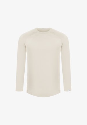 Lange mouw, lichtbeige top van zachte stof. Beschikt over een ronde halslijn en een gebogen zoom, met subtiele stikseldetails op de schouders.