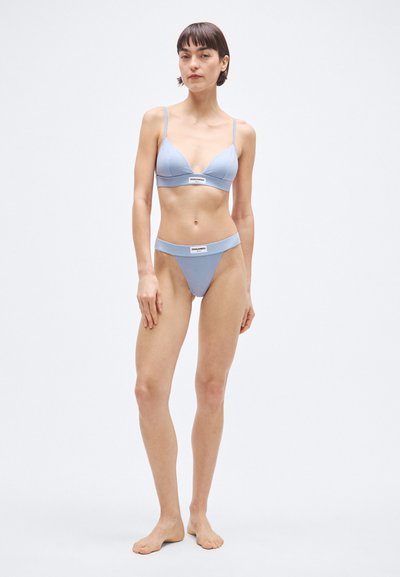 Világoskék bikini szett háromszög alakú bralette-tel és hozzáillő tangával. Puha anyagból készült, minimalista dizájn, a szalagon logóval.