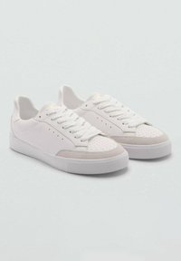 Pantofi sport albi cu un superior neted, vârf rotund, detalii perforate și tălpi plate din cauciuc. Include șireturi tonale și accente din piele întoarsă.