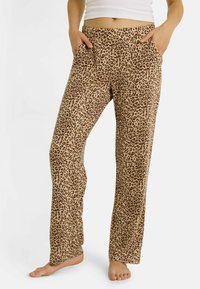 Pantalon de détente à imprimé léopard dans des tons beige et marron. Tissu doux avec une coupe décontractée et deux poches latérales. Taille plate.