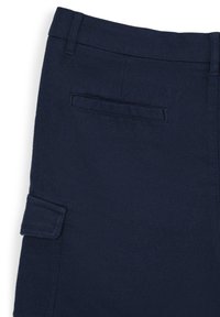Pantaloni cargo blu con un tessuto testurizzato. Presentano una tasca laterale a toppa e tasche posteriori, progettati per praticità e abbigliamento casual.