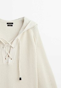 Gebreide katoenen trui in off-white met een capuchon, diepe V-hals met vetersluiting, geribbelde textuur en contrasterende koordjes.