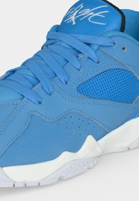 Μπλε αθλητικό παπούτσι με υφή υφάσματος, οπές στο πλάι, παχιά λευκή σόλα και μπλε κορδόνια δεμένα πάνω στη γλώσσα.