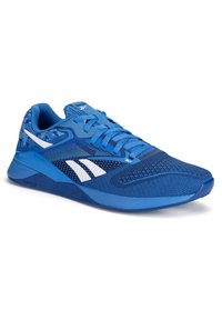 Zila sporta kurpe ar strukturētu augšējo daļu, sietveida akcentiem un baltu zīmolu. Ievērojama ar apaļu purngalu, auklu aizdari un rakstainu papēdi.